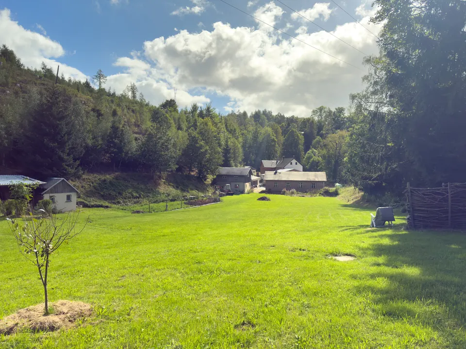 Weite Wiese mit Blick auf die Gebäude der Gnauckmühle