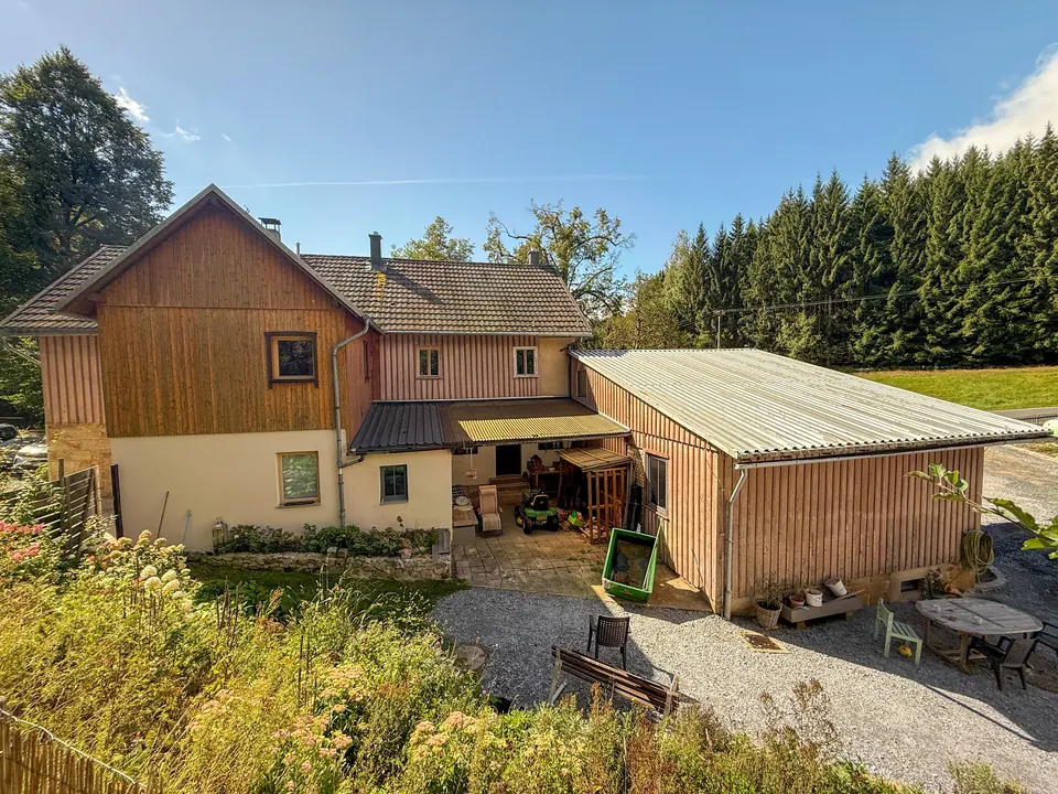 Holzverkleidetes Wohnhaus mit überdachtem Sitzplatz
