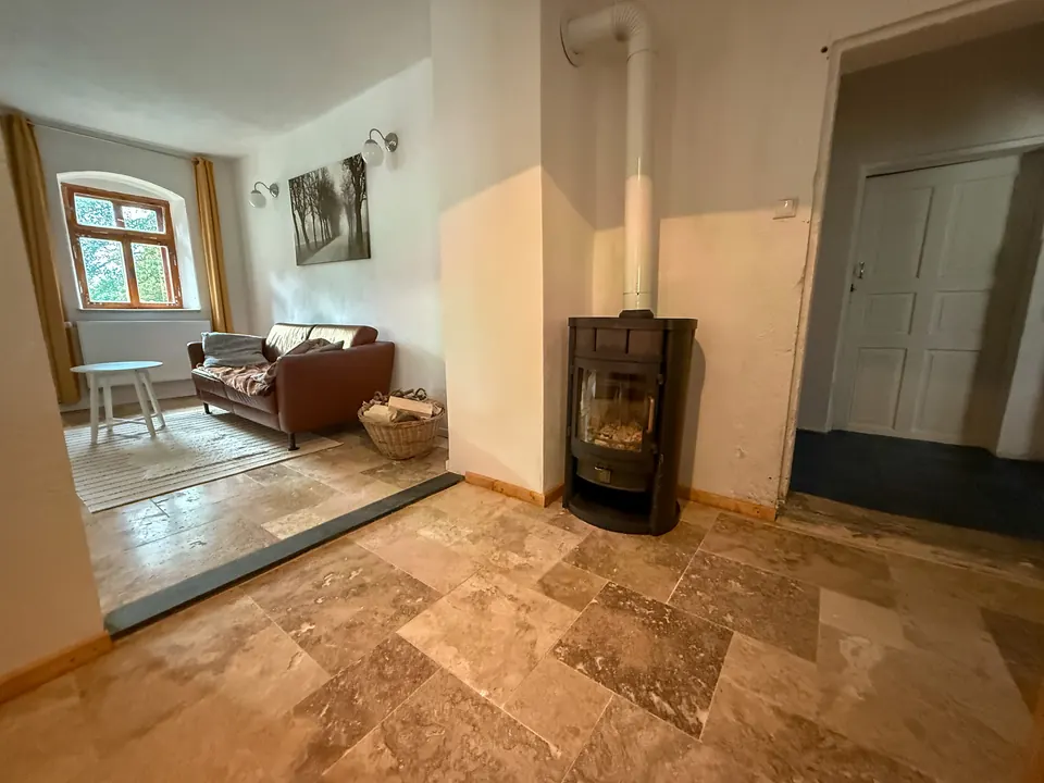 Wohnraum mit Kaminofen und Natursteinboden