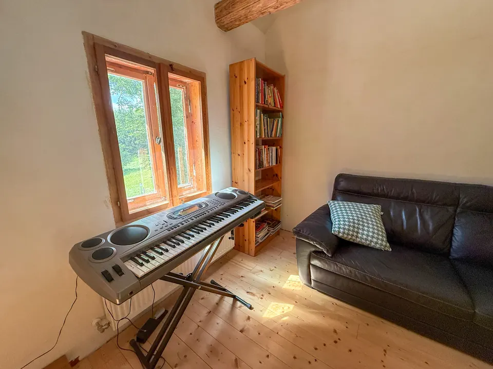 Großer Wohnraum unter dem Dach mit Holzbalken und Dielen